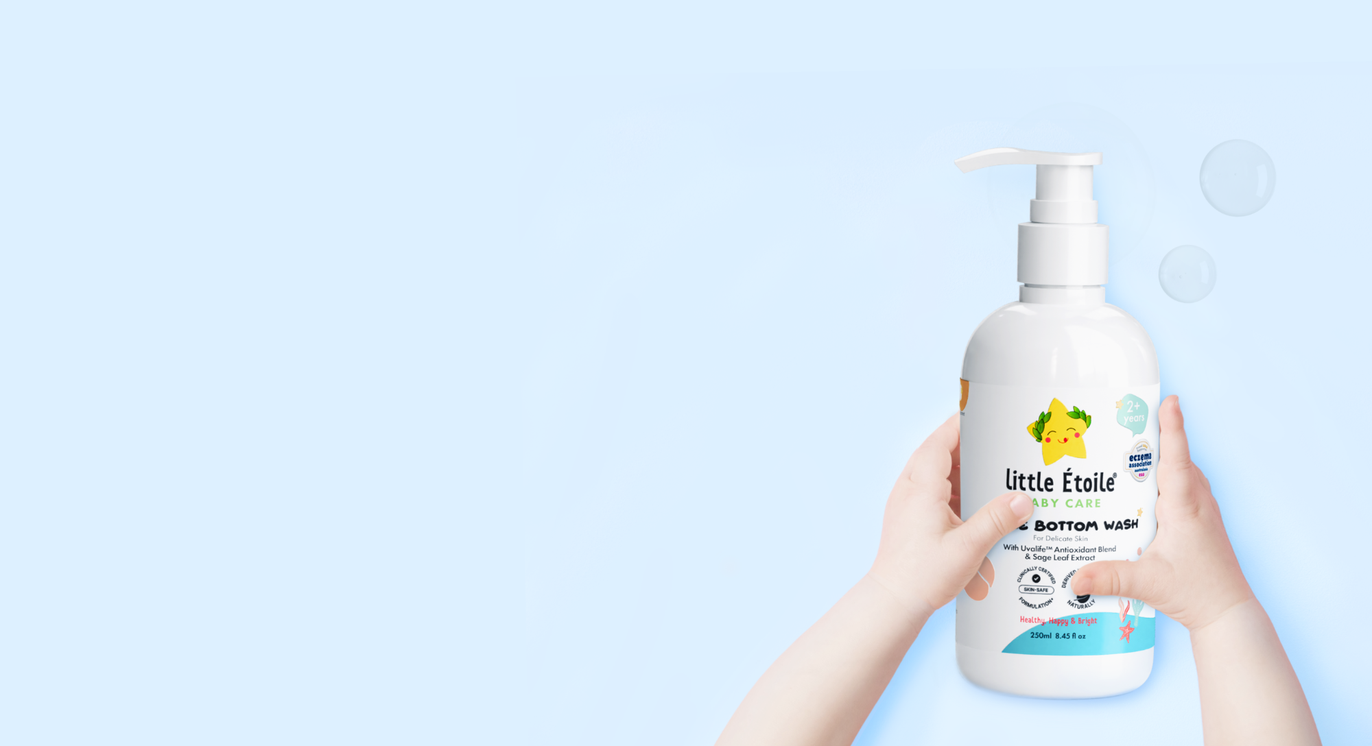 baby holding Little Étoile Gentle Bottom Wash bottle